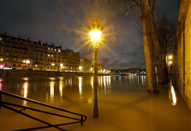 A street lamp is seen on the flooded banks of the River Seine in Paris, France, after days of almost non-stop rain caused flooding in the country, January 25, 2018. REUTERS/Christian Hartmann