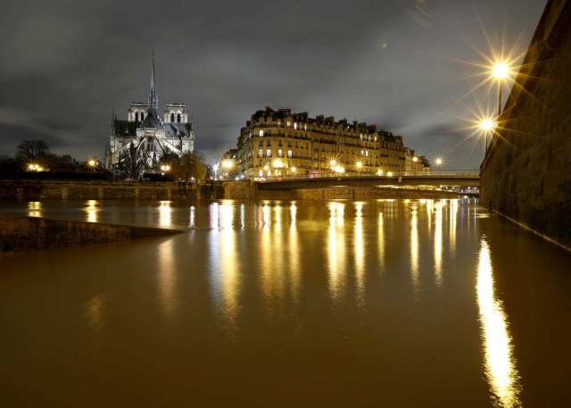 A general view shows the Notre Dame Cathedral at night, on the flooded banks of the River Seine in Paris, France, after days of almost non-stop rain caused flooding in the country, January 25, 2018. REUTERS/Christian Hartmann TPX IMAGES OF THE DAY