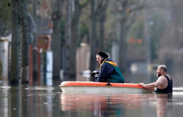 Residents use a small boat in a flooded street of Villeneuve-Saint-Georges, near Paris, France January 26, 2018. REUTERS/Christian Hartmann