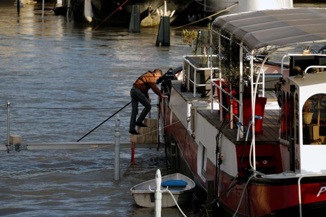 A man returns to his houseboat as the Seine River overflows its banks as heavy rains throughout the country have caused flooding, in Paris, France, January 26, 2018. REUTERS/Pascal Rossignol