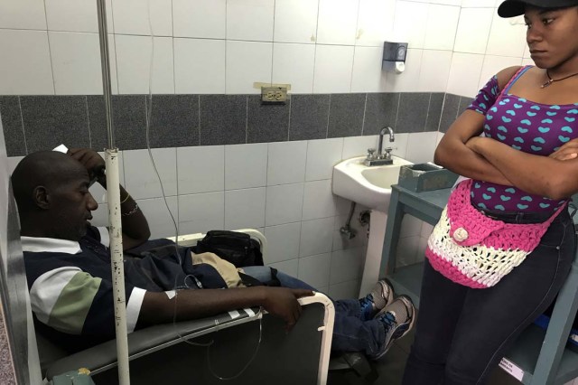 Pablo Tejada, a kidney transplanted patient, receives treatment in front of his daughter at a state hospital in Caracas, Venezuela February 7, 2018. Tejada has been unable to find the drugs needed to keep his body from rejecting the transplanted kidney and his immune system is attacking the foreign organ. Picture taken February 7, 2018. REUTERS/Carlos Garcia Rawlins