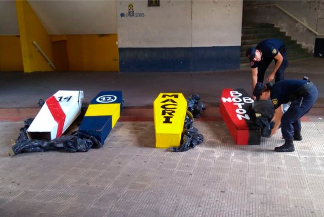 Esta foto publicada por Noticias Argentinas muestra a los policías de la provincia de Santa Fe arreglando cuatro féretros simulados pintados con los colores de los equipos de fútbol argentino River Plate, Boca Juniors y Newell's Old Boys, así como uno leyendo el apellido del presidente argentino Mauricio Macri, que fueron requisados en el estadio de Rosario Central antes del partido de la Superliga Argentina contra Godoy Cruz, en Rosario, provincia de Santa Fe, Argentina, el 3 de marzo de 2018. / AFP PHOTO / NOTICIAS ARGENTINAS / HO / Argentina OUT