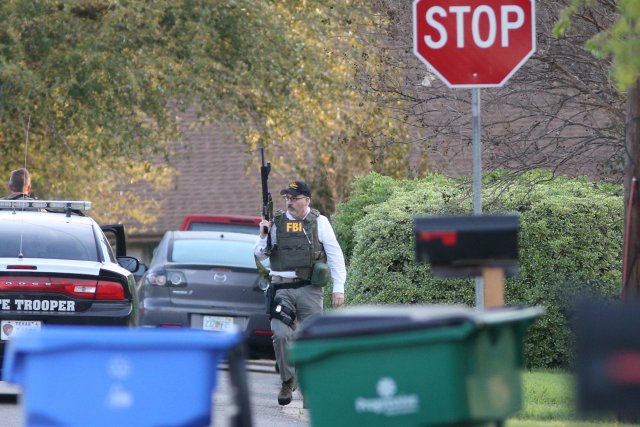 Law enforcement personnel investigate the surroundings of a house linked to the bomber in Pflugerville, Texas, U.S., March 21, 2018. REUTERS/Loren Elliott