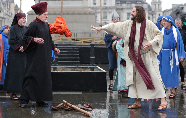 Actor James Burke-Dunsmore (2R) plays the role of Jesus Christ, during a performance of Wintershall's 'The Passion of Jesus' on Good Friday in Trafalgar Square in London on March 30, 2018.  The Passion of Jesus tells the story from the Bible of Jesus's visit to Jerusalem and his crucifixion. On Good Friday 20,000 people gather to watch the Easter story in central London. One hundred Wintershall players bring their portrayal of the final days of Jesus to this iconic location in the capital. / AFP PHOTO / Daniel LEAL-OLIVAS