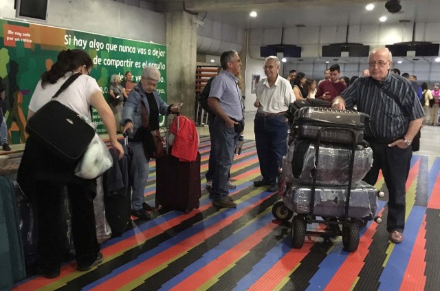 People remain stranded at Caracas' international airport on April 6, 2018 after Venezuela suspended flights of Panama's Copa Airlines in an escalating diplomatic row. Panama on April 5 ordered Venezuela's ambassador out and recalled its own envoy to the country as Caracas imposed sanctions on senior Panamanian officials and suspended flights in an escalating diplomatic row. At issue is Panama's alignment with other Latin American countries as well as the European Union, Canada and the United States that have taken measures against President Nicolas Maduro's and his government on the grounds that he is undemocratically tightening his hold on power. / AFP PHOTO / Federico PARRA