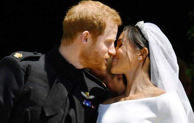 Prince Harry and Meghan Markle kiss on the steps of St George's Chapel in Windsor Castle after their wedding in Windsor, Britain, May 19, 2018. Ben Birchall/Pool via REUTERS