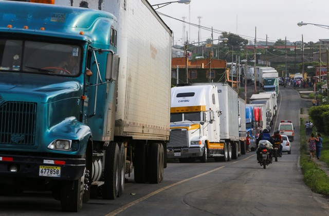 People past parked trucks on Pan-American highway during a protest against President Daniel Ortega's government in El Crucero, Nicaragua June 7, 2018. REUTERS/Oswaldo Rivas
