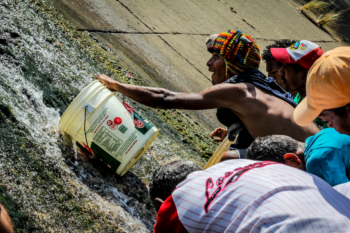 La desesperación en FOTOS: Caraqueños se surten de agua insalubre en el Río Guaire